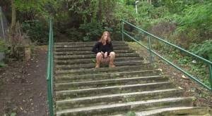 Natural redhead Chrissy Fox squats for a pee on a set of public steps on shefanatics.com