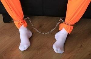 Female prisoner is left alone while cuffed in an orange jumper and white socks on shefanatics.com