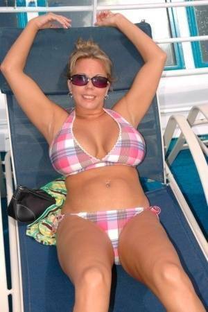 Hugely busty Amber Lynn Bach doffs her bikini to spread her legs wide nude on shefanatics.com