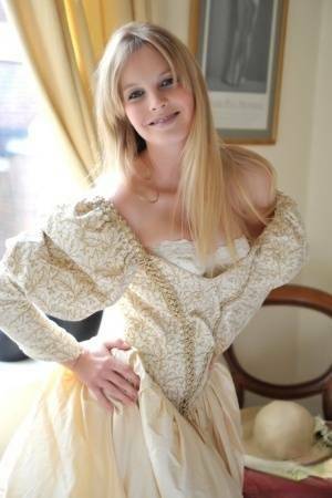 Blonde girl Rose takes off her petticoat to model in a girdle and nylons on shefanatics.com