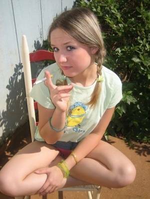 Cute teenage babe Shelby takes a smoke break and flashes us her perky tits on shefanatics.com